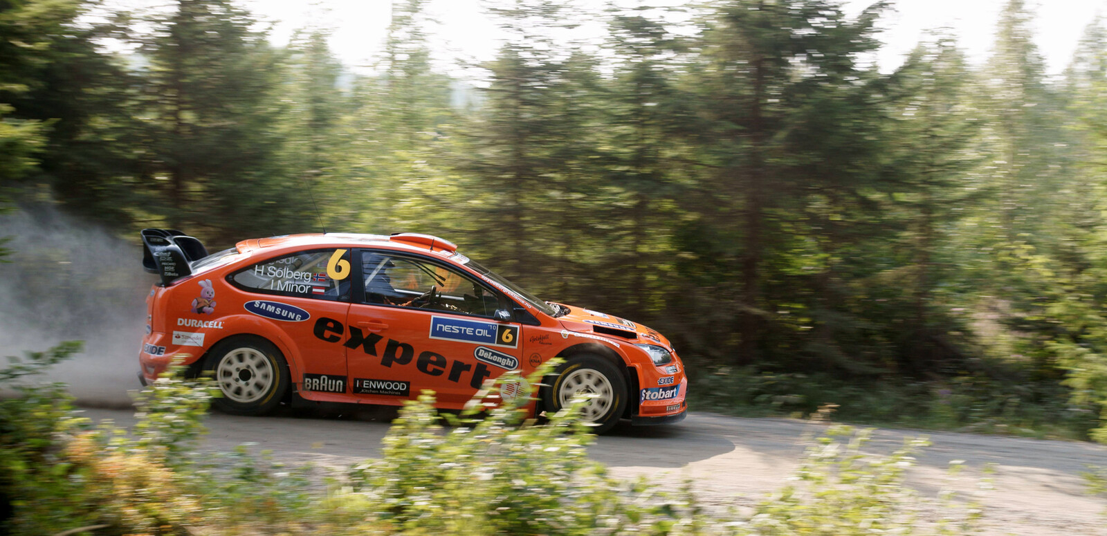 Ein orangefarbener Ford-Rallyewagen f�hrt beim Shakedown in Rannakyl�, Muurame, schr�g von vorn �ber die Strecke. Die Aufnahme stammt vom 29. Juli 2010.