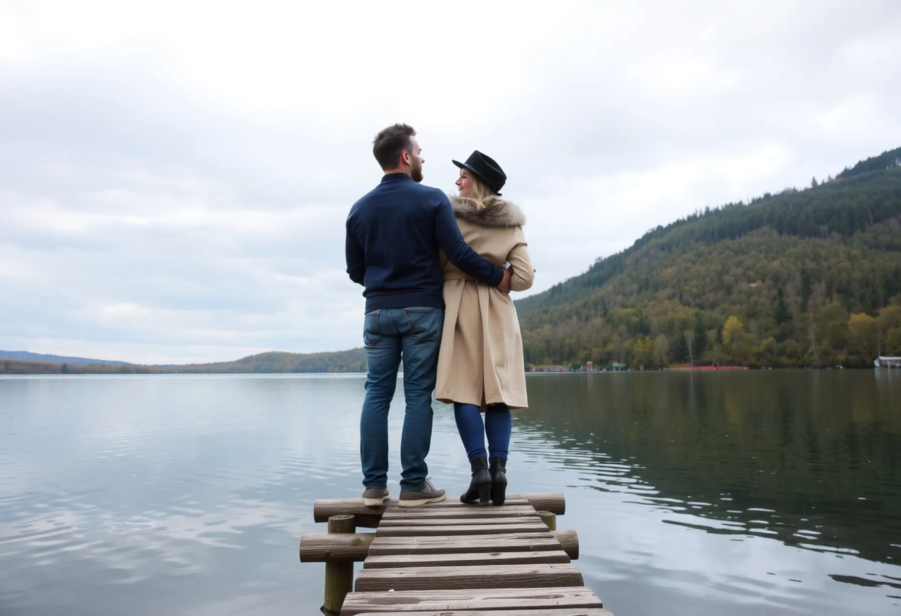 Paar auf Holzsteg an einem ruhigen See im frühen Herbst