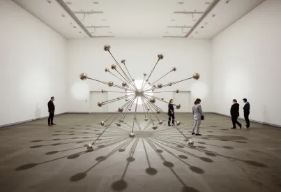 Kinetische Installation aus metallischen Armen mit Spiegelreflexionen und Lichtmustern in einem hell erleuchteten Raum
