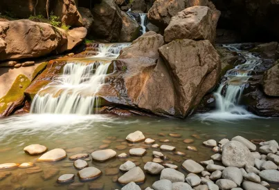 Wasserfall in schmaler Schlucht: Naturkulisse aus moosbedeckten Felsen und Pflanzen im Morgenlicht