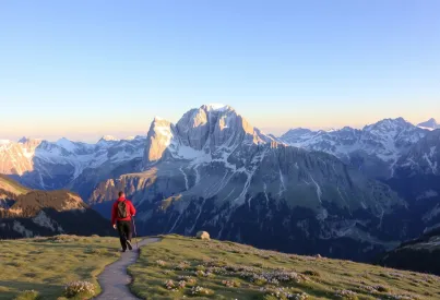 Landschaftsansicht der Dolomiten: Wanderer auf Pfaden, Alpenblumen und Alpendohle im milden Licht