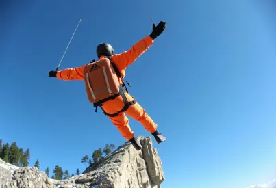 Base-Jumper in leuchtendem Wingsuit beim Sprung von Felsklippe im Lauterbrunnental, Schweiz