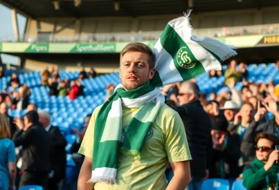 Fußballfan im Stadion mit SV Werder Bremen-Schal inmitten begeisterter Menschenmenge
