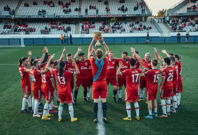 Fußballmannschaft feiert Sieg mit Trophäe im Stadion