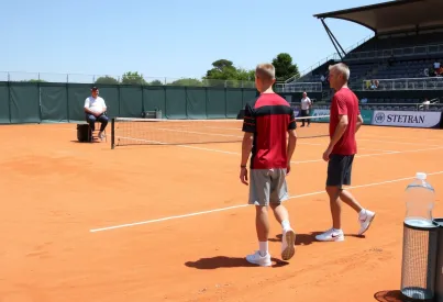 Tennisplatz bei regionalem Turnier in Südfrankreich: Spieler und Schiedsrichter im Einsatz