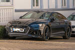 Ein dunkler Audi RS5 Sportback steht in Binz auf R�gen und ist schr�g von vorn zu sehen.