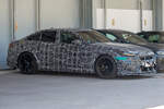 Ein getarnter BMW M5 G90 als Testfahrzeug steht in M�nchen auf einem Parkplatz, aufgenommen schr�g von vorn.