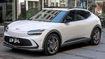 Ein wei�er Genesis GV60 steht bei der IAA 2023 schr�g von vorn vor einem Geb�ude.