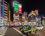 Yasukuni-dori Avenue at night with vehicles and colorful neon street signs, Kabukichō, Shinjuku, Tokyo, Japan.